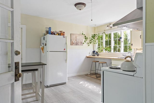 4 Wilson St, Topsham, ME 04086 - kitchen featuring white appliances, wall chimney exhaust hood, and wainscoting