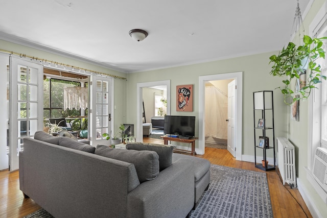 4 Wilson St, Topsham, ME 04086 - living area featuring radiator heating unit, wood finished floors, crown molding, and french doors