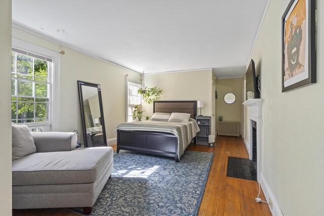 4 Wilson St, Topsham, ME 04086 - bedroom featuring radiator heating unit, crown molding, wood finished floors, and a fireplace with flush hearth