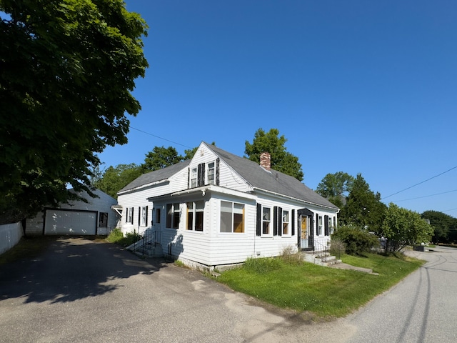 view of front facade featuring a garage and an outdoor structure