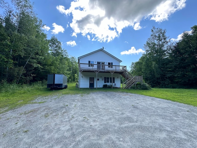 view of front of home featuring a front lawn and a deck