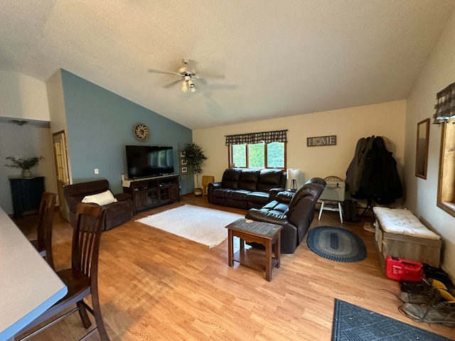 living room featuring ceiling fan, vaulted ceiling, a textured ceiling, and light hardwood / wood-style floors