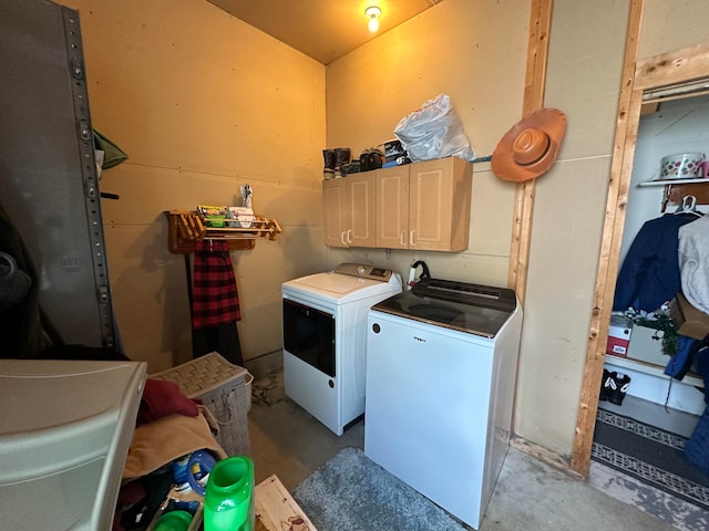 laundry room with washing machine and clothes dryer and cabinets