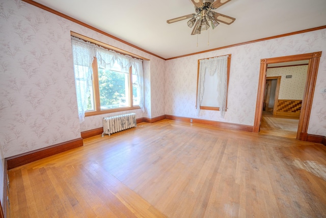 443 S Union Rd, Union, ME 04862 - empty room with a ceiling fan, wallpapered walls, radiator heating unit, crown molding, and wood finished floors