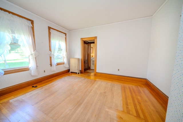 unfurnished room with ornamental molding, radiator heating unit, and light hardwood / wood-style floors