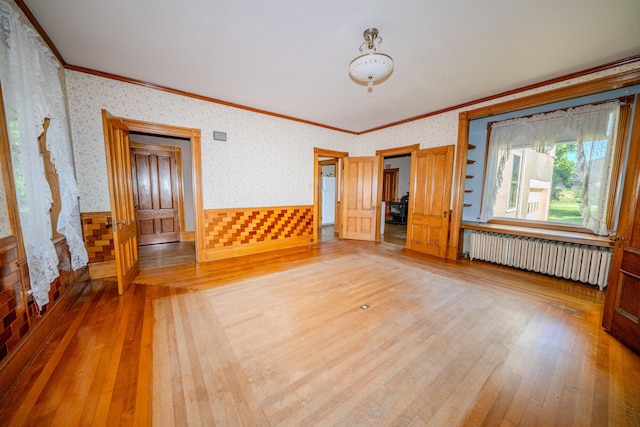 443 S Union Rd, Union, ME 04862 - unfurnished living room with radiator, ornamental molding, light wood-type flooring, and wallpapered walls
