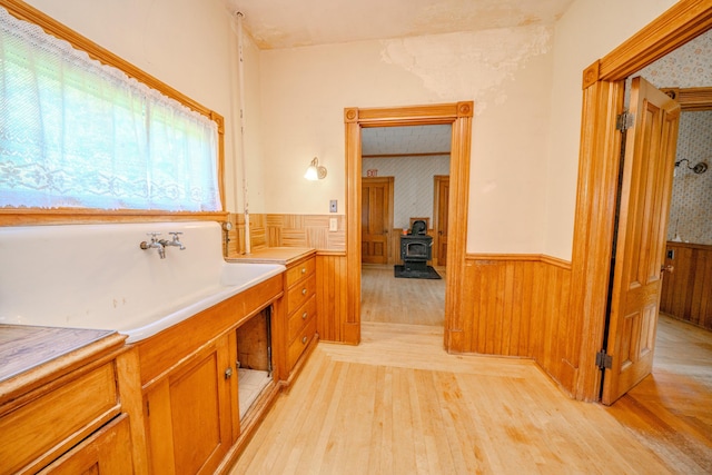 443 S Union Rd, Union, ME 04862 - full bath with a wainscoted wall, wood finished floors, a wood stove, a freestanding bath, and wallpapered walls
