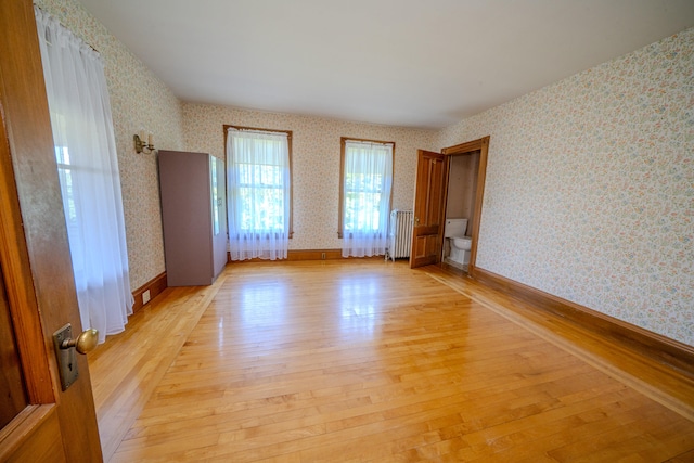 empty room featuring radiator and light hardwood / wood-style floors