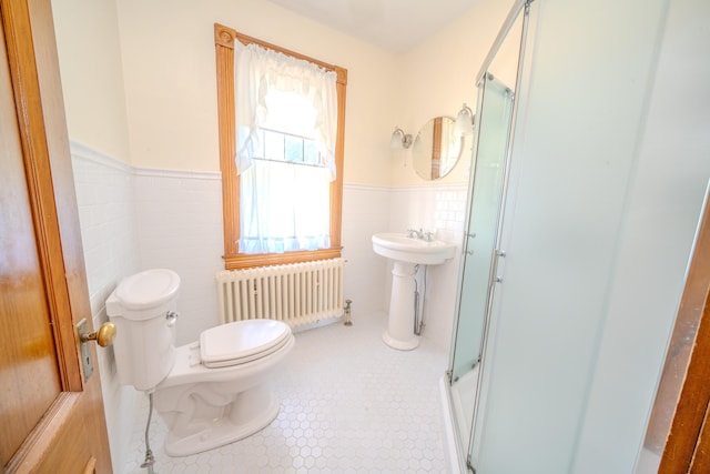 443 S Union Rd, Union, ME 04862 - full bath featuring tile walls, a shower with shower door, radiator, toilet, and a wainscoted wall