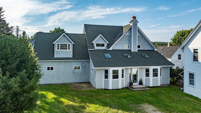 back of property featuring a yard, roof with shingles, and a chimney