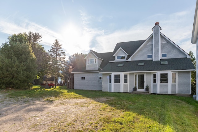 back of property featuring a lawn and roof with shingles