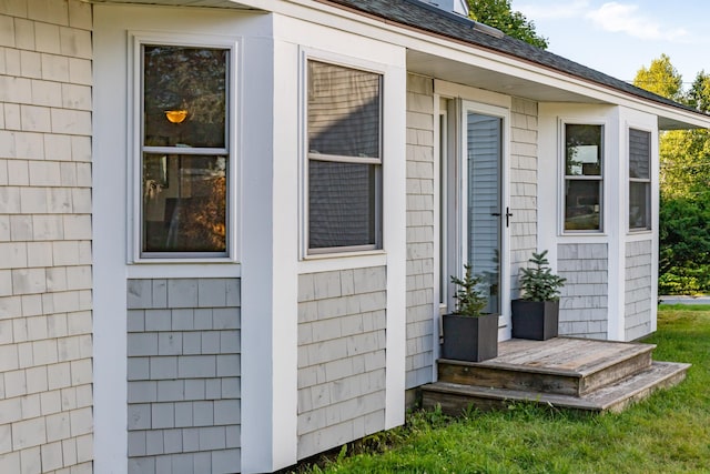 entrance to property featuring roof with shingles