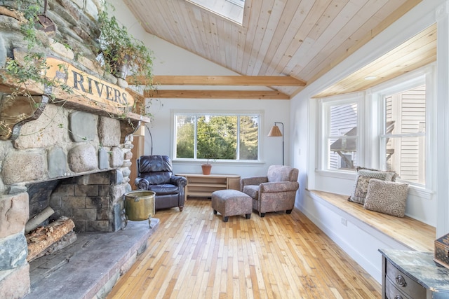 sitting room with a fireplace, light hardwood / wood-style flooring, lofted ceiling with skylight, and wood ceiling