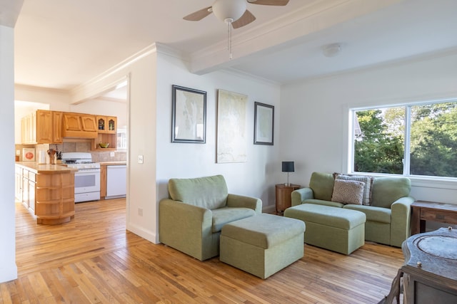 living room with beam ceiling, a ceiling fan, light wood-style floors, and ornamental molding