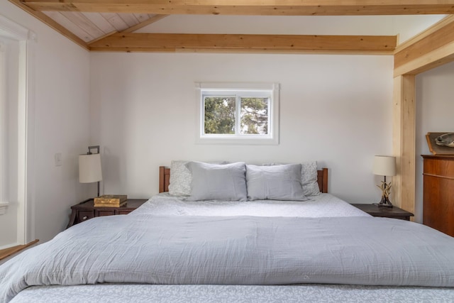 bedroom featuring vaulted ceiling with beams