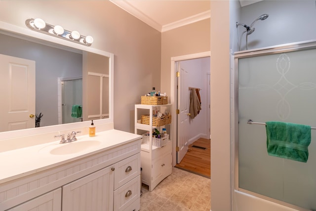 bathroom with vanity, bath / shower combo with glass door, ornamental molding, and hardwood / wood-style flooring