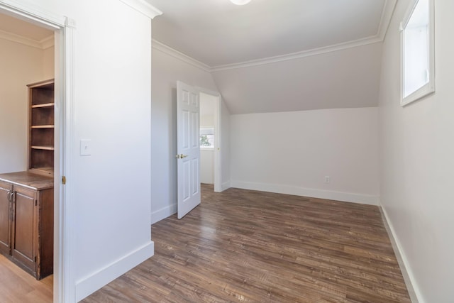 additional living space with baseboards, wood finished floors, and vaulted ceiling