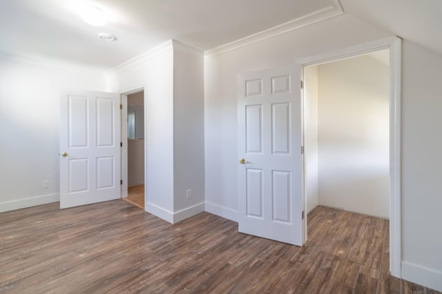 unfurnished bedroom with baseboards, dark wood finished floors, crown molding, and vaulted ceiling