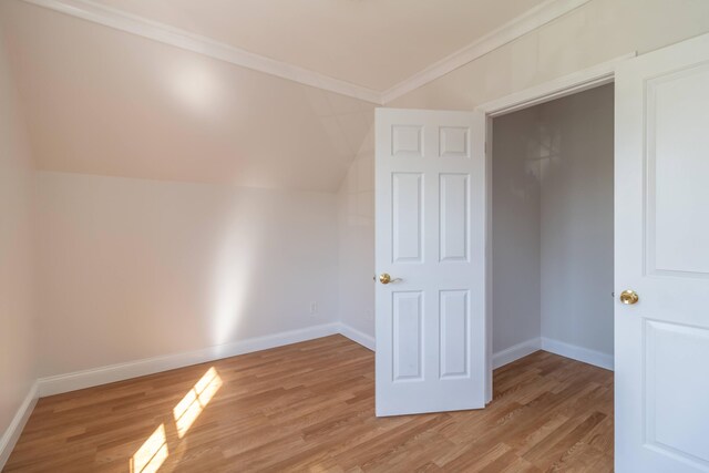 interior space with vaulted ceiling, light wood-style floors, and baseboards