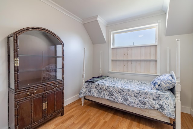 bedroom with baseboards, wood finished floors, and crown molding