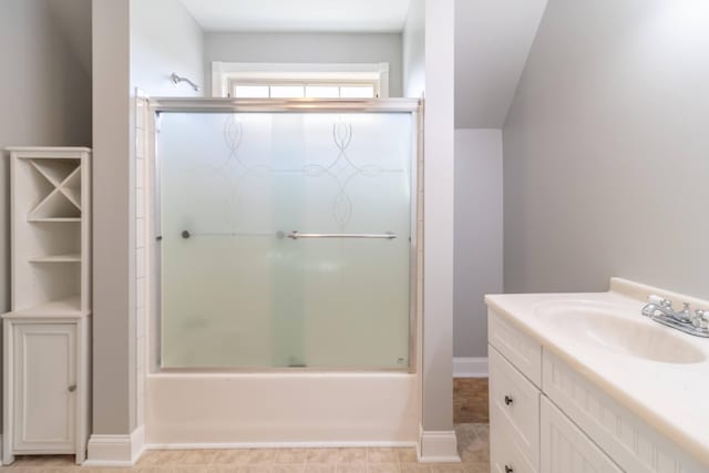 full bath featuring vanity, baseboards, and bath / shower combo with glass door