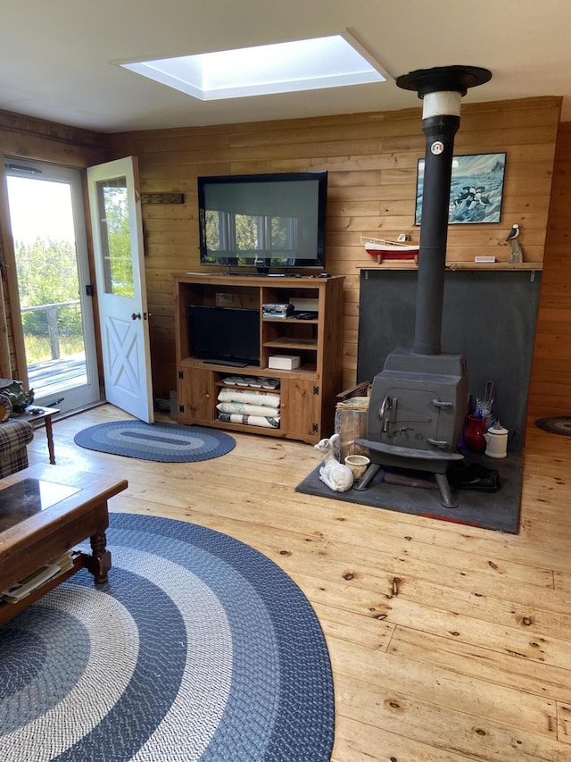91 Mcsorley Rd, Great Cranberry, Cranberry Isles, ME 04625 - living room featuring hardwood / wood-style floors, wood walls, a skylight, and a wood stove