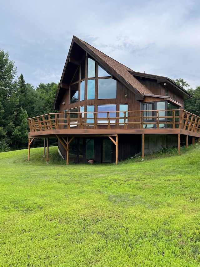 back of house with a wooden deck and a lawn