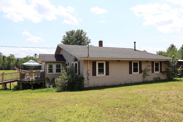 rear view of property with a yard and a wooden deck