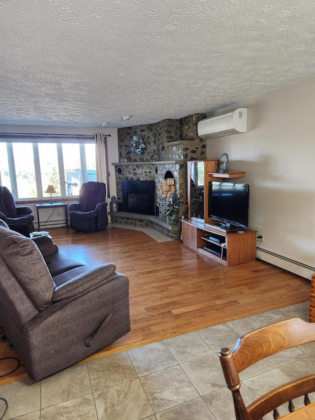 living area featuring wood finished floors, a fireplace, an AC wall unit, a textured ceiling, and a baseboard heating unit