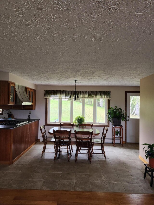 tiled dining area featuring a textured ceiling and a chandelier