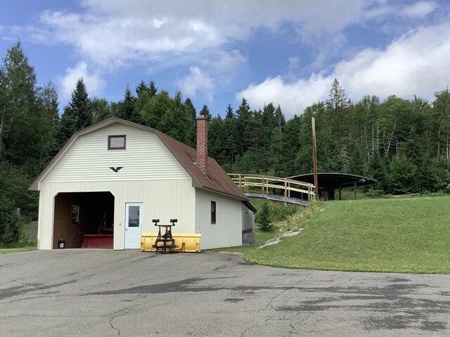 view of outdoor structure featuring a garage and a lawn