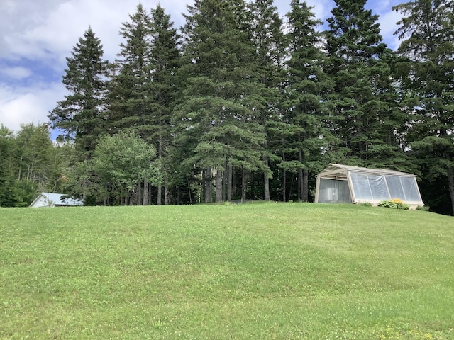 view of yard featuring an outbuilding and a greenhouse