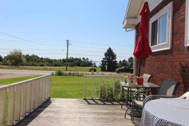 wooden terrace featuring a yard