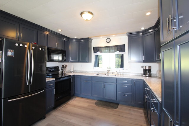 kitchen featuring light hardwood / wood-style flooring, black appliances, sink, and light stone counters