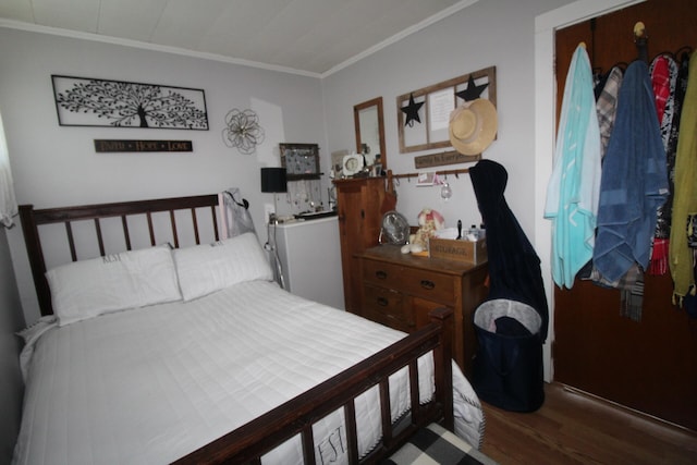 bedroom with ornamental molding and hardwood / wood-style flooring