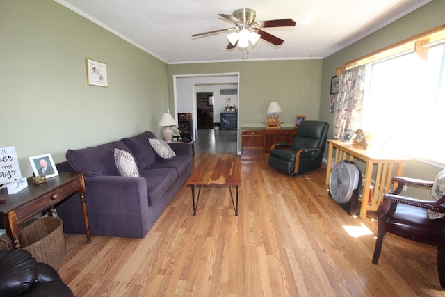 living room with crown molding, light hardwood / wood-style flooring, and ceiling fan