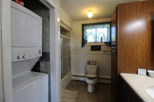 clothes washing area with stacked washer / drying machine, wooden walls, and a baseboard radiator