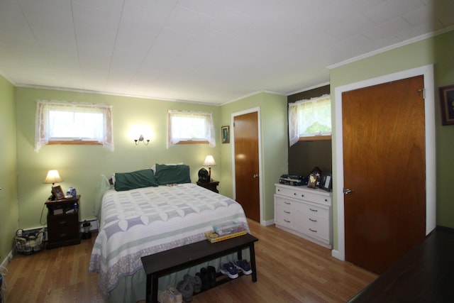 bedroom with ornamental molding and wood-type flooring