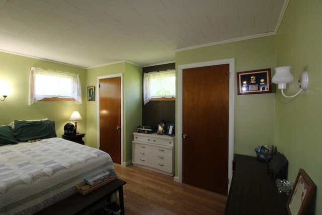 bedroom featuring ornamental molding and wood-type flooring