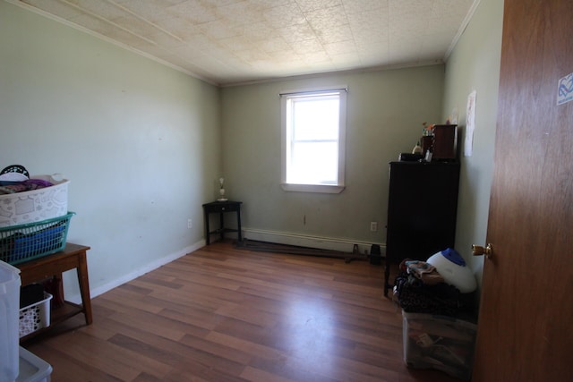 miscellaneous room featuring crown molding, a baseboard heating unit, and dark hardwood / wood-style floors