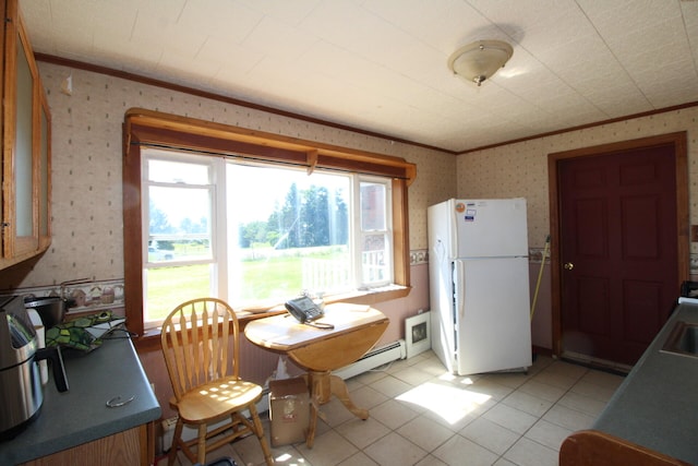 dining space with baseboard heating, crown molding, light tile patterned floors, and plenty of natural light