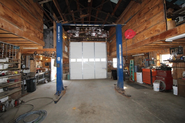 garage with a workshop area and wooden walls