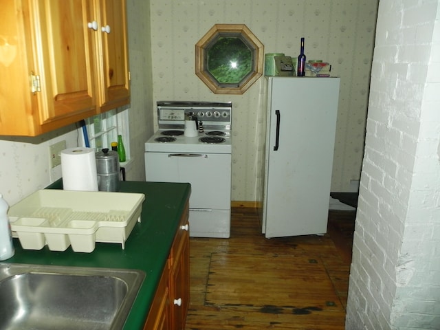 kitchen featuring dark wood-type flooring and white appliances