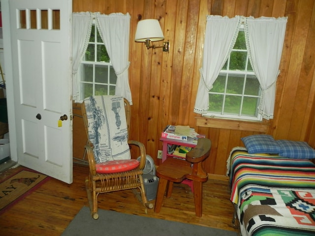 bedroom with wood walls and hardwood / wood-style floors