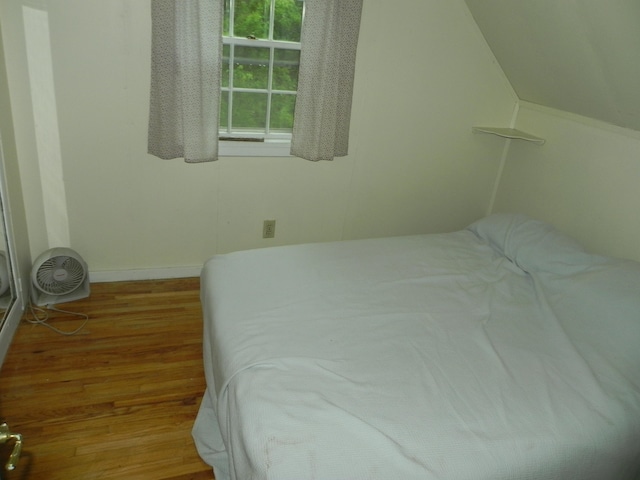 bedroom with hardwood / wood-style flooring and multiple windows