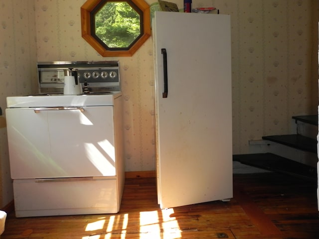 interior space with white fridge, hardwood / wood-style flooring, and stove