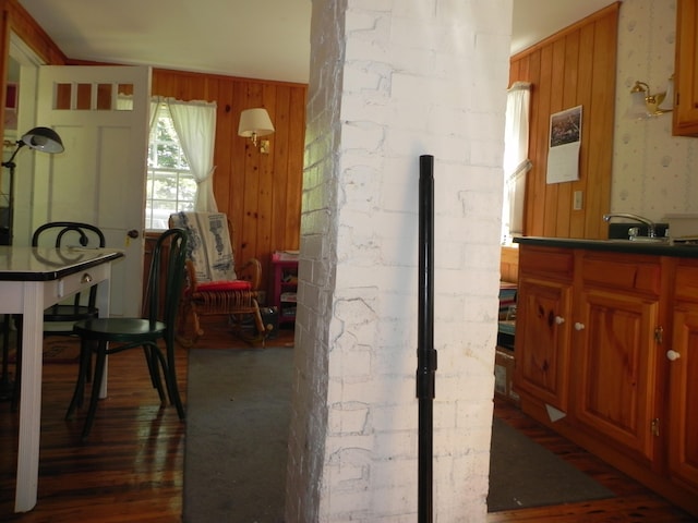 interior space with wooden walls, hardwood / wood-style floors, and brick wall