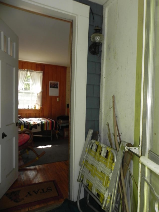 interior space with hardwood / wood-style flooring and wooden walls