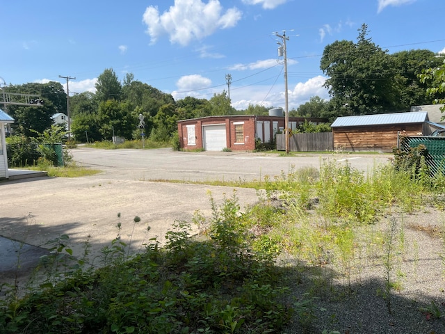 view of yard featuring a garage and an outbuilding