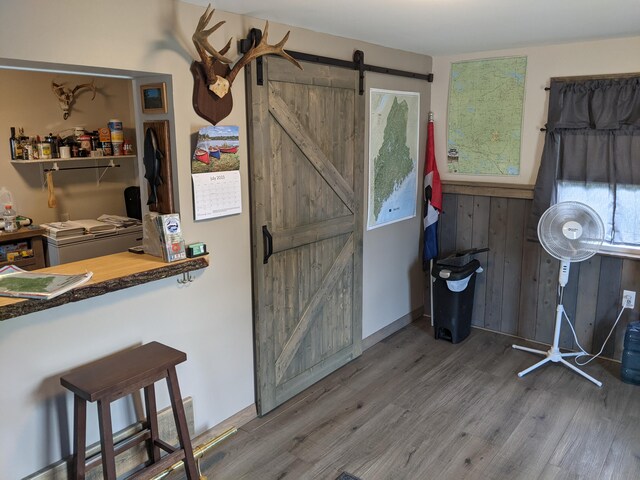 kitchen featuring a kitchen breakfast bar, a barn door, and hardwood / wood-style floors